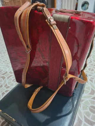 Acordeón rojo, teclas blancas y negras, caja tpte