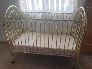 Cuna metálica dorada