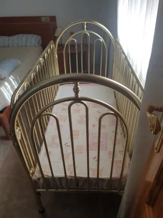 Cuna metálica dorada