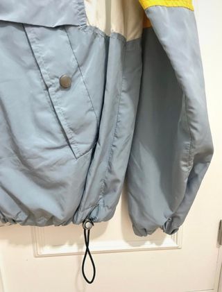 Chaqueta cortavientos azul y amarilla