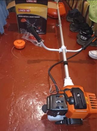 Desbrozadora de gasolina naranja y gris.