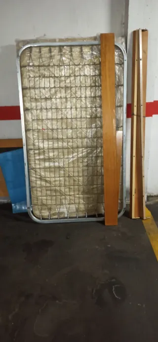 Cama de madera, somier de metal y colchón.