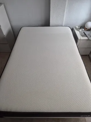 Colchón con base tapizada y 6 patas  metálicas.