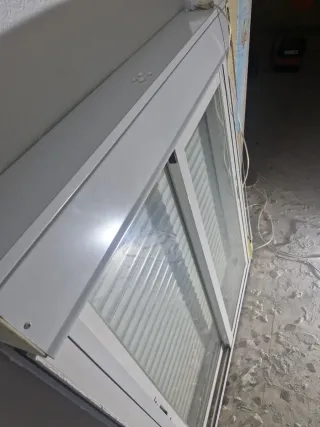 Ventana corredera blanca con persiana