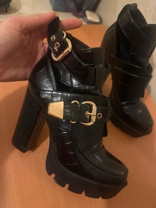 Botas de tacón negras con hebillas doradas