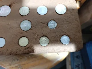 Ladrillo antiguo con monedas incrustadas