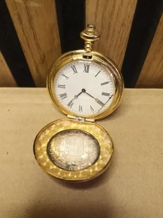 Reloj de bolsillo dorado con moneda