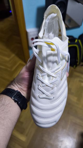 Botas de fútbol blancas y doradas