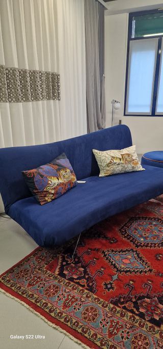 Divano letto in tessuto microfibra blu.