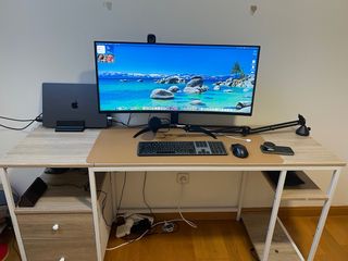 Escritorio curvo con monitor, webcam y micro