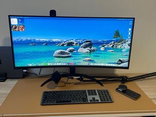 Escritorio curvo con monitor, webcam y micro