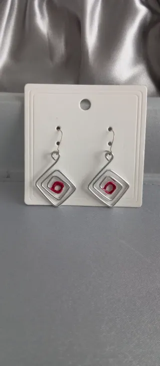 Pendientes plateados con detalle rojo