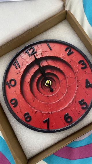 Reloj de pared rojo con diseño espiral