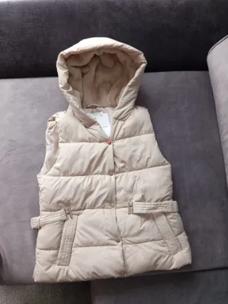 Chaleco beige con capucha forrada  de pelo .