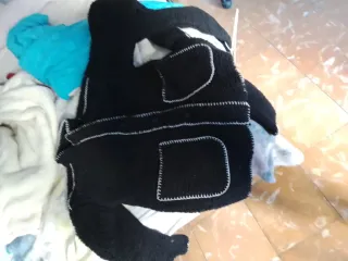 Chaqueta negra con costuras blancas y bufanda.