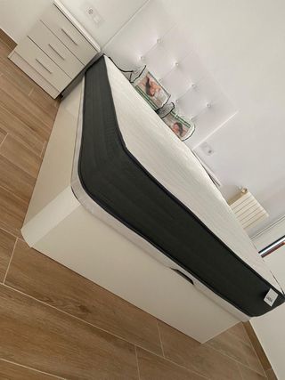 Cama con cabecero blanco y colchón