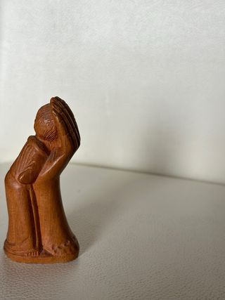 Piccola scultura in legno di un bambino che riposa