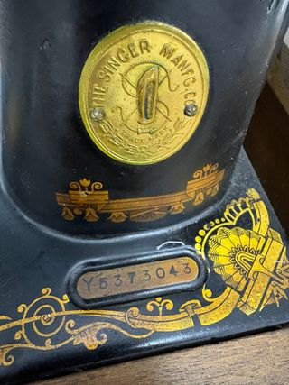 Máquina de coser antigua SINGER negra y dorada.