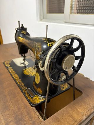 Máquina de coser antigua SINGER negra y dorada.