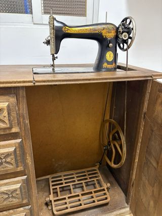 Máquina de coser antigua SINGER negra y dorada.