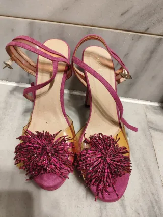 Zapatos tacón rosa con tiras y flecos.