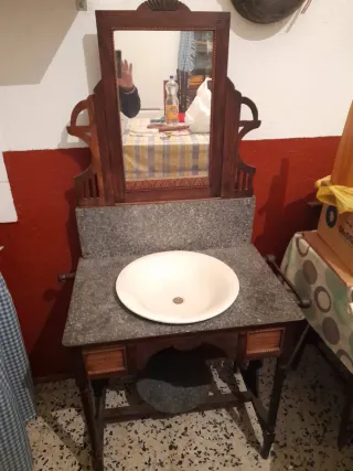 Mueble tocador antiguo con espejo y lavabo.