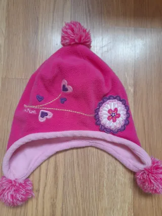 Gorro infantil rosa con pompones.