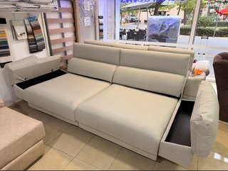 Sofá de tela beige con patas altas