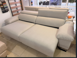 Sofá de tela beige con patas altas