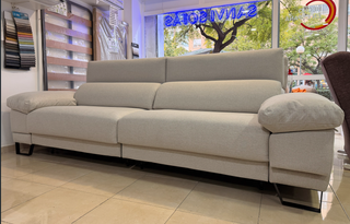 Sofá de tela beige con patas altas