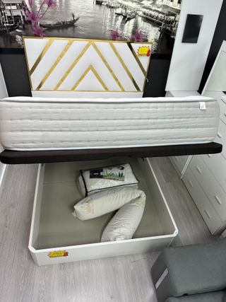 Cama individual blanca con cabecero dorado