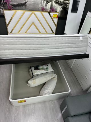 Cama individual blanca con cabecero dorado