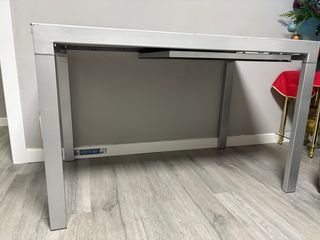 Mesa de comedor extensible de cristal y metal.