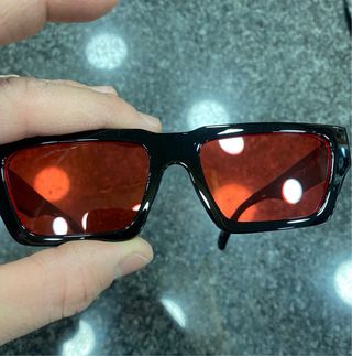 Occhiali da sole neri con lenti rosse