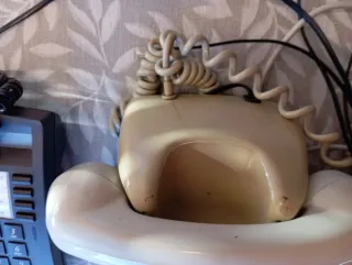 Teléfono antiguo beige y uno negro Alcatel.