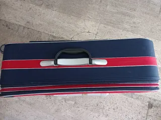 Valigia trolley blu e rossa con combinazione