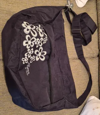 Mochila bandolera negra con flores blancas