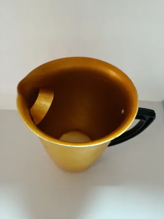 Jarra antigua dorada con asa negra