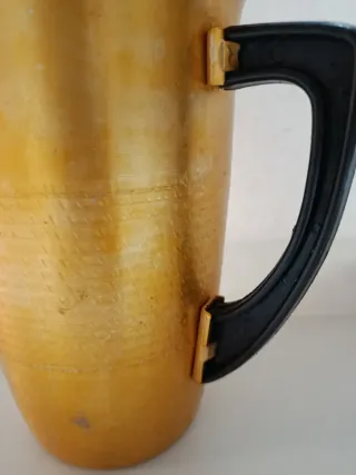 Jarra antigua dorada con asa negra