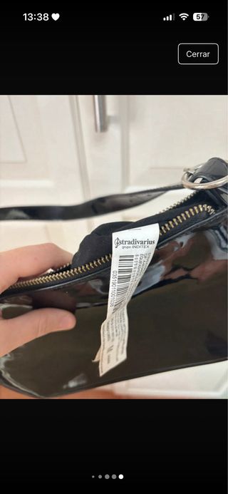 Bolso de hombro negro con tachuelas y de piel.