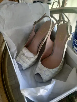 Zapatos de tacón blancos y dorados