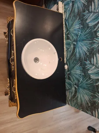 Mueble de baño negro y dorado.