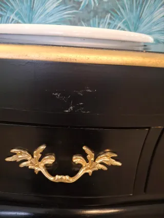 Mueble de baño negro y dorado.