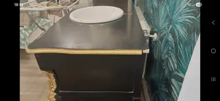 Mueble de baño negro y dorado.
