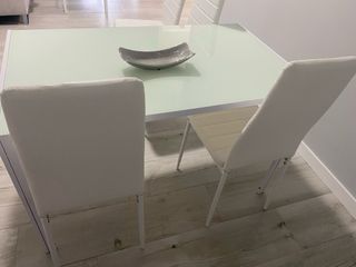 Mesa de cristal con 4 sillas blancas