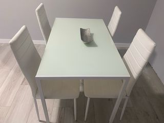 Mesa de cristal con 4 sillas blancas