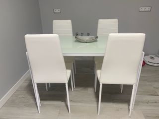 Mesa de cristal con 4 sillas blancas