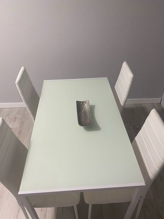 Mesa de cristal con 4 sillas blancas