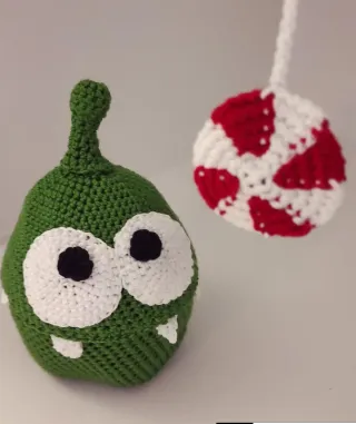 Peluche tejido verde con ojos grandes