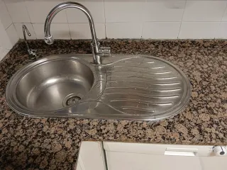 Varios electrodomésticos, mármol, fregadero,grifo.